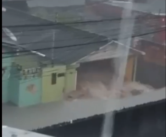 Uma enxurrada de água atinge uma casa no Bairro Zumbi.