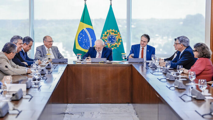 Presidente Lula durante assinatura da lei, acompanhado do vice-presidente Geraldo Alckmin (esq.) e do ministro da Educação, Camilo Santana (dir.).