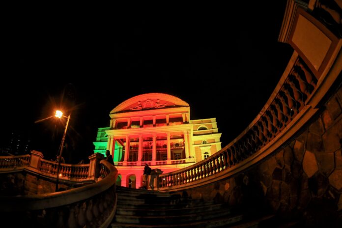 Teatro Amazonas iluminado com as cores do RS: Verde, vermelho e amarelo.